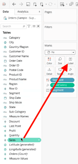 arrow highlighting path to drag sales field into label element of pie chart in tableau